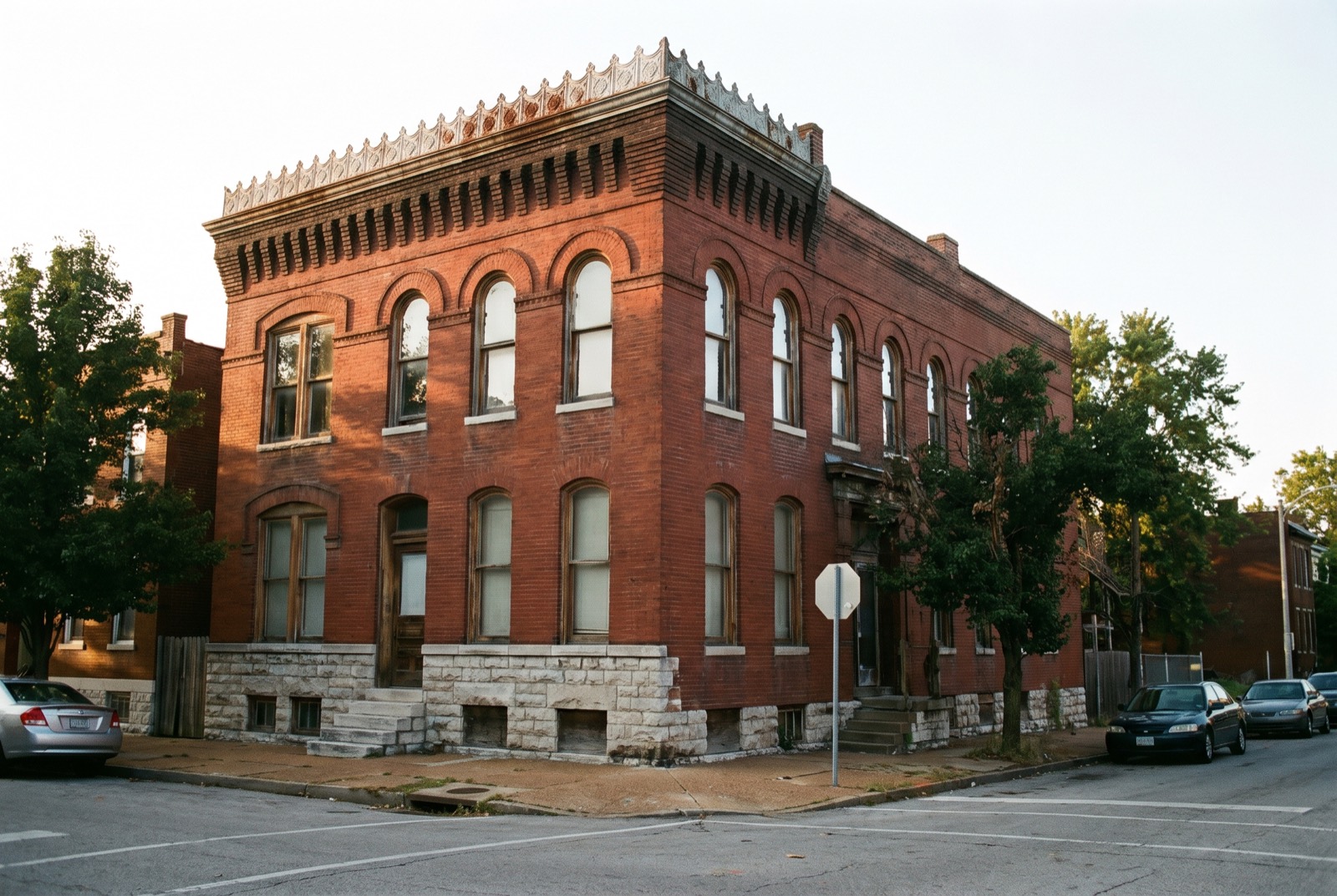 A two-story brick flat with arched windows and a corbelled brick cornice